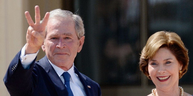 DALLAS, TX - APRIL 25: Former President George W. Bush shows three fingers for 'W' as his wife and former first lady Laura