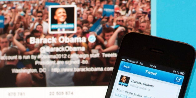 A person poses with a cell phone in front of a computer screen to check Barack Obama's tweet on November 7, 2012 in Paris after his re-election as US president. Barack Obama brought his sophisticated social media campaign to an emotional climax, proclaiming his victory on Twitter and Facebook just as TV networks were breaking the news. The post was his most re-tweeted -- 472,000 shares in three hours -- according to Twitter's politics account @gov. It was also the most popular ever, topping a message from singer Justin Bieber, website BuzzFeed said. AFP PHOTO / LIONEL BONAVENTURE (Photo credit should read LIONEL BONAVENTURE/AFP/Getty Images)