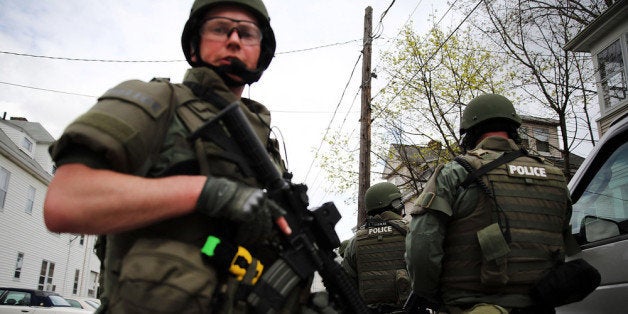 WATERTOWN, MA - APRIL 19: Members of a police SWAT team conduct a door-to-door search for 19-year-old Boston Marathon bombing suspect Dzhokhar A. Tsarnaev on April 19, 2013 in Watertown, Massachusetts. After a car chase and shoot out with police, one suspect in the Boston Marathon bombing, Tamerlan Tsarnaev, 26, was shot and killed by police early morning April 19, and a manhunt is underway for his brother and second suspect, 19-year-old Dzhokhar A. Tsarnaev. The two men are suspects in the bombings at the Boston Marathon on April 15, that killed three people and wounded at least 170. (Photo by Spencer Platt/Getty Images)