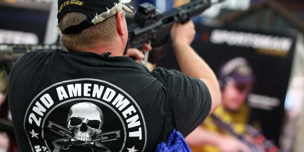 HOUSTON, TX - MAY 05: An attendee wears a 2nd amendment shirt while inspecting an assault rifle during the 2013 NRA Annual Meeting and Exhibits at the George R. Brown Convention Center on May 5, 2013 in Houston, Texas. More than 70,000 people attended the NRA's 3-day annual meeting that featured nearly 550 exhibitors, a gun trade show and a political rally. (Photo by Justin Sullivan/Getty Images)