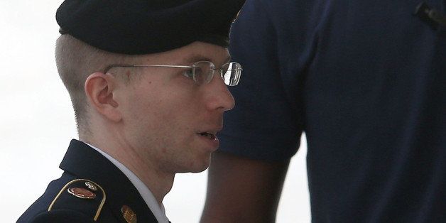 FORT MEADE, MD - AUGUST 21: US Army Private First Class Bradley Manning is escorted by military police as he arrives for his sentencing at military court facility for the sentencing phase of his trial on August 21, 2013 in Fort Meade, Maryland. Manning was found guilty of several counts under the Espionage Act, but acquitted of the most serious charge of aiding the enemy. (Photo by Mark Wilson/Getty Images)
