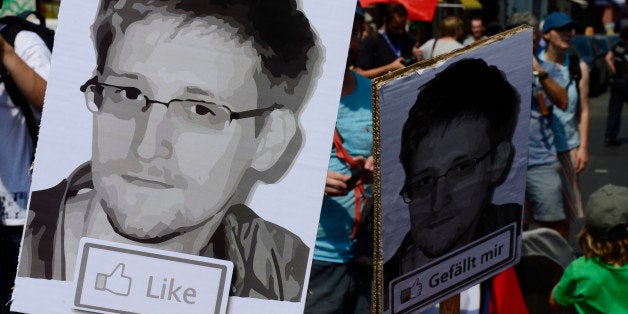 Demonstrators hold placards featuring an image of former US intelligence contractor Edward Snowden as they take part in a protest against the US National Security Agency (NSA) collecting German emails, online chats and phone calls and sharing some of it with the country's intelligence services in Berlin on July 27, 2013. AFP PHOTO / JOHN MACDOUGALL (Photo credit should read JOHN MACDOUGALL/AFP/Getty Images)