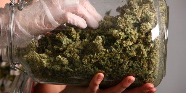 Lakewood, CO - MARCH, 4: Sales associate, Crystal Guess handles a jar of cannabis inside a Good Meds medical cannabis center
