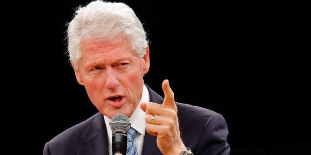 PRETORIA, SOUTH AFRICA - AUGUST 07: Former US President and founder of the Clinton Foundation Bill Clinton reads a discussion onstage during the 'Embrace Tomorrow - A Conversation Without Borders' program hosted in conjunction with the Nelson Mandela Foundation at the Pretoria Parade Grounds on August 7, 2013 in Pretoria, South Africa. The Clintons are traveling through Africa to address health issues including HIV testing, decontamination of drinking water and education on Malaria. (Photo by Jemal Countess/Getty Images)