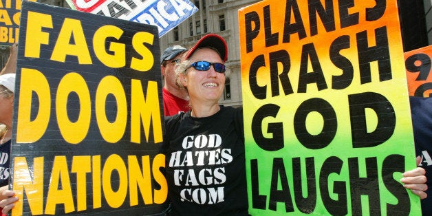 NEW YORK - JULY 4: Shirley Phelps-Roper holds up signs as she joins fellow members of the Westboro Baptist Church, from Topeka, Kansas, as they protest across the street from Ground Zero July 4, 2004 in New York City. The church members believe that because of homosexuals and America's rebelious and immoral conducts, God has brought on acts of terrorism as a way of punishing society. (Photo by Monika Graff/Getty Images)