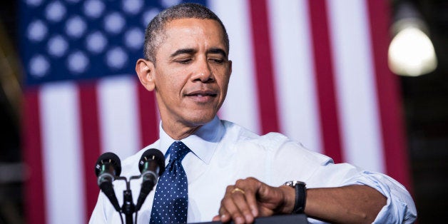 US President Barack Obama looks at his watch while speaking at the Ford Kansas City Stamping Plant September 20, 2013 in Libe