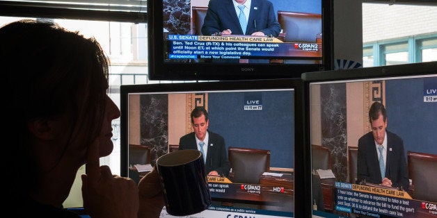A journalist watches C-SPAN TV on computer screens showing US Senator Ted Cruz (R-TX) on September 25, 2013 in Washington,DC