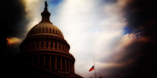 Dramatic post processing of the United States Capitol Building with the United States Flag lowered to half staff.