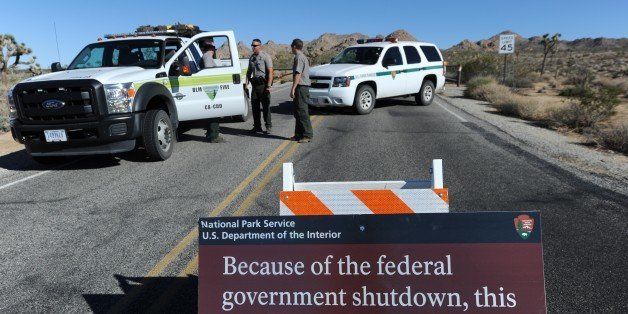 US Park Rangers stand at the closed gate to Joshua Tree National Park, in Joshua Tree, California on October 2, 2013, the second day of the US government shutdown. Hundreds of tourists staying in landmark US national parks like Yosemite and the Grand Canyon face a deadline October 3, 2013 to leave due to the government shutdown. The National Park Service closed its gates on its 401 sites as soon as the shutdown went into effect Tuesday morning, October 1, 2013, leaving visitors -- including many from overseas -- frustrated at park entrances across the country. AFP PHOTO / Robyn Beck (Photo credit should read ROBYN BECK/AFP/Getty Images)