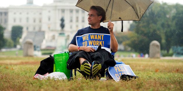 UNITED STATES - OCTOBER 07: Jeffrey Wismer, a furloughed employee of AmeriCorps, sits on the Mall along 3rd Street to draw attention to the plight of workers during the ongoing government shutdown. (Photo By Tom Williams/CQ Roll Call)