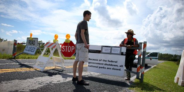 MIAMI, FL - OCTOBER 07: Mirta Maltes a U.S. Park Ranger law enforcement officer speaks with Christoph Zuercher, a tourist from Switzerland, at a road closed sign leading to the Everglades National Park after he discovered the park was closed on October 7, 2013 in Miami, Florida. The park is closed as the United States House and Senate are into day 7 of not being able to agree on a bill to fund the United States government. National Parks around the nation are closed along with other federal services. (Photo by Joe Raedle/Getty Images)