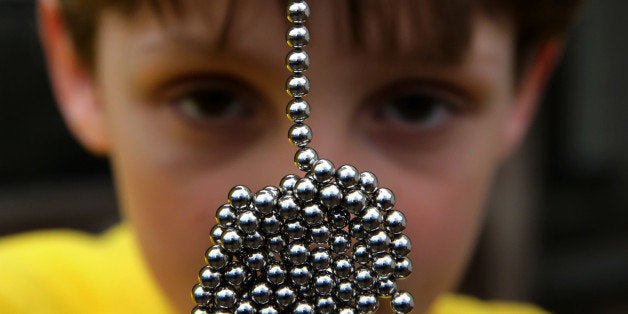 Brandon Bruski, 9, holds dozens of Buckyballs on Thursday, April 11, 2013 in Crystal Lake, Illinois. In January, Brandon accidentally swallowed two balls from this set of the small magnetic desk toys. The magnets left Brandon with a small and large intestine bound together. Emergency surgery was required. (Chris Sweda/Chicago Tribune/MCT via Getty Images)