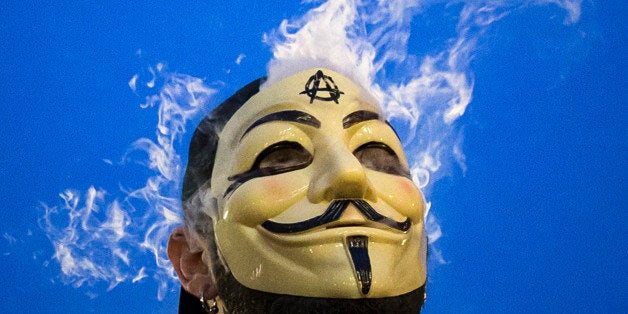 Vapor passes through a Guy Fawkes mask as a man smokes while joining supporters of the Anonymous movement who were taking part in the global "Million Mask March" protests in Union Square, New York November 5, 2014. REUTERS/Elizabeth Shafiroff (UNITED STATES - Tags: CIVIL UNREST POLITICS TPX IMAGES OF THE DAY)