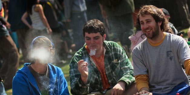 BOULDER, CO - APRIL 20: Young men smoke a marijuana cigarette during a 'smoke out' with thousands of others April 20, 2010 a