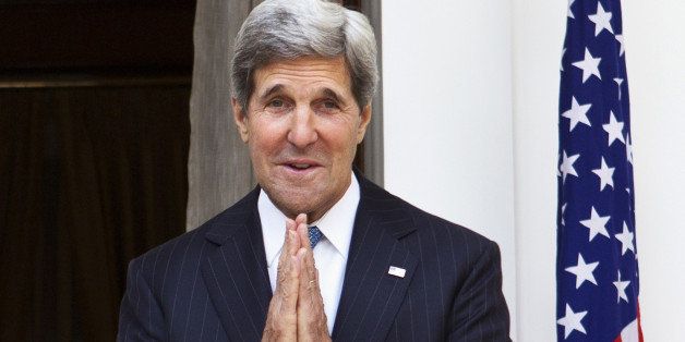 US Secretary of State John Kerry makes a gesture of greeting to the media at the close of a photo opportunity with unseen Indian Foreign Minister Salman Khurshid at Hyderabad House in New Delhi on June 24, 2013. Secretary of State John Kerry will on June 24 try to ease India's concerns about the impending withdrawal of US troops from war-torn Afghanistan as he embraces a greater role for the regional power. AFP PHOTO/POOL/Jacquelyn Martin (Photo credit should read JACQUELYN MARTIN/AFP/Getty Images)
