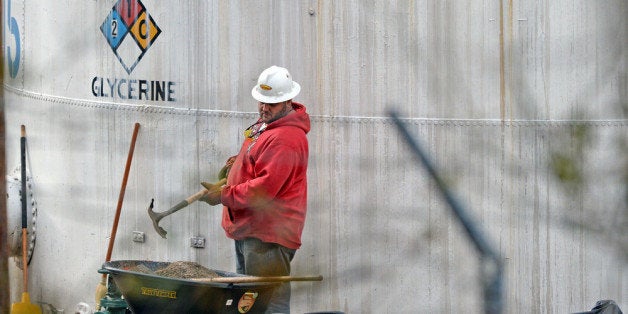 CHARLESTON, WV - JANUARY 10: An unidentified worker at Freedom Industries shovels NAPA premium oil absorbent on January 10, 2014 in Charleston, West Virginia. West Virginia American Water determined Thursday MCHM chemical had 'overwhelmed' the plant's capacity to keep it out of the water from a spill at Freedom Industries in Charleston. An unknown amount of the hazardous chemical contaminated the public water system for potentially 300,000 people in West Virginia. (Photo by Tom Hindman/Getty Images)