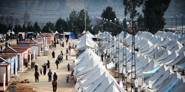 Syrian refugees walk among tents at Karkamis' refugee camp on January 16, 2014 near the town of Gaziantep, south of Turkey. T