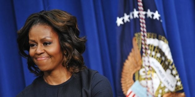 US First Lady Michelle Obama smiles as US President Barack Obama speaks during an event on expanding college opportunity in the South Court Auditorium of the Eisenhower Executive Office Building, next to the White House on January 16, 2014 in Washington, DC. Michelle Obama turns 50 on January 17, 2014 as one of America's most respected women, but despite her popularity she is yet to break the mold as First Lady -- one of the toughest jobs in politics. The former Michelle Robinson did not take to politics quickly in the shadow of her high wattage husband and was even a liability early on in his 2008 campaign. But she has evolved into a polished performer -- and at key moments in the president's reelection bid breathed new life into his political persona, when he seemed weary and uninspired. AFP PHOTO/Mandel NGAN (Photo credit should read MANDEL NGAN/AFP/Getty Images)