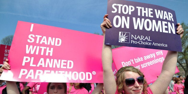 Participants shout slogans and display placards during a rally to 'stand up for women's health' at the National Mall in Washington, DC, on April 7, 2011. Participants from across the country gathered in a show of support for Planned Parenthood, the family-planning group in the crosshairs of the budget battle blazing in Congress, where a federal shutdown is looming. AFP PHOTO/Jewel Samad (Photo credit should read JEWEL SAMAD/AFP/Getty Images)