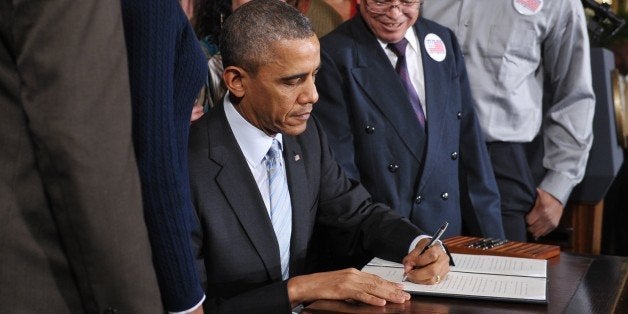 US President Barack Obama signs an executive order raising the federal minimum wage to $10.10 on new federal contracts in the East Room of the White House on February 12, 2014 in Washington, DC. President Obama first announced the measure during his State of the Union address. Because the measure applies only to new contracts, officials have said it will affect just a few hundred thousand workers. That's a small percentage of the more than 2 million federal contractors. AFP PHOTO/Mandel NGAN (Photo credit should read MANDEL NGAN/AFP/Getty Images)