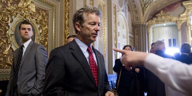 US Republican Senator Rand Paul of Kentucky talks with a staff member as he walks to participate in a cloture vote to end debate in the Senate on a bill to raise the debt limit until March 2015 at the US Capitol in Washington, DC, on February 12, 2014. The Senate later voted 55-43 to pass the debt ceiling increase and send it to US President Barack Obama for his signature. AFP PHOTO / Saul LOEB (Photo credit should read SAUL LOEB/AFP/Getty Images)