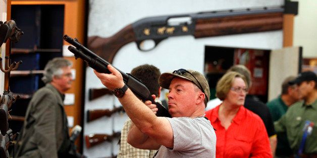 An attendee looks through the scope of a Freedom Group Inc. Remington brand gun during the 2013 National Rifle Association (NRA) Annual Meetings & Exhibits at the George R. Brown Convention Center in Houston, Texas, U.S., on Saturday, May 4, 2013. After the U.S. Senate defeated a proposed expansion of background checks on gun purchases, the NRA's annual conference has a celebratory atmosphere. Yet as the festivities began, gun-control advocates swarmed town halls, organizing petitions and buying local ads to pressure senators from Alaska to New Hampshire to reconsider the measure that failed by six votes on April 17. Photographer: Aaron M. Sprecher/Bloomberg via Getty Images