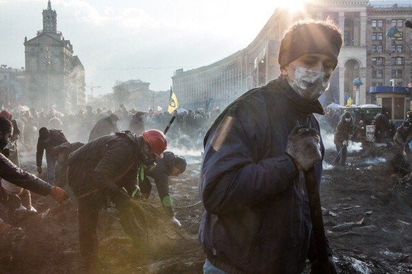 <br>Anti-government protesters clear ashes and debris from a newly occupied portion of Independence Square on Feb. 20, 2014, 