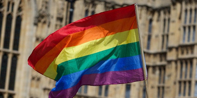 A gay campaigner waves the rainbow flag during a rally outside the Houses of Parliament as the Marriage (Same Sex Couples) Bill gets an unopposed third reading by the Lords in central London on July 15, 2013. Gay marriage was set to be legalised in England and Wales after the controversial Bill introducing it cleared the Lords today. AFP PHOTO/ANDREW COWIE (Photo credit should read ANDREW COWIE/AFP/Getty Images)