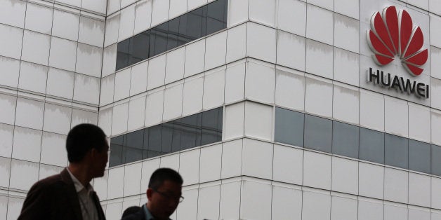 People walk by a building on the Huawei campus in the Chinese city of Shenzhen on April 7, 2013. Chinese tech giant Huawei sa