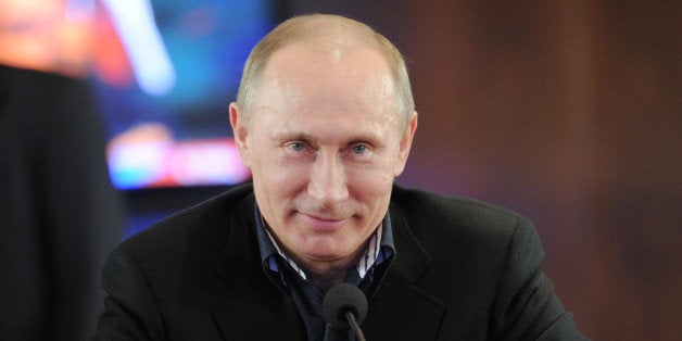 Russia's Prime Minister and presidential candidate Vladimir Putin smiles as visits his campaign staff in Moscow, late on Marc