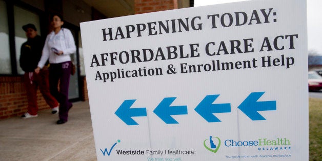 An Affordable Care Act application and enrollment help sign stands outside a Westside Family Healthcare center in Bear, Delaware, U.S., on Thursday, March 27, 2014. Six million Americans have signed up for private health plans under Obamacare, President Barack Obama said, a symbolic milestone for a government that has struggled to get the law off the ground. Photographer: Andrew Harrer/Bloomberg via Getty Images