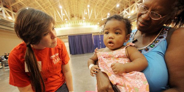 NEW ORLEANS - AUGUST 31: Volunteer Jennah Hanos (L) talks to patient Jackie Simmons (R) and her granddaughter Paige Simmons at a free medical clinic for the uninsured at the Ernest N. Morial Convention Center August 31, 2010 in New Orleans, Louisiana. The two day clinic is sponsored by the National Association of Free Clinics (NAFC). The New Orleans health care system was decimated by Hurricane Katrina and has yet to recover. (Photo by Mario Tama/Getty Images)