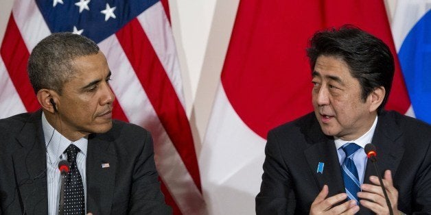 US President Barack Obama listens to Japanese Prime Minister Shinzo Abe (R) during a trilateral meeting with the South Korean president at the US ambassador's residence in The Hague on March 25, 2014 after they attended the Nuclear Security Summit (NSS). Obama hosted the much-anticipated first meeting between the Asian leaders with relations between Tokyo and Seoul at their lowest ebb in years, mired in emotive issues linked to Japan's 1910-45 colonial rule and a territorial dispute, as well as Japan's use of South Korean 'comfort women' sex slaves in wartime brothels. AFP PHOTO / Saul LOEB (Photo credit should read SAUL LOEB/AFP/Getty Images)