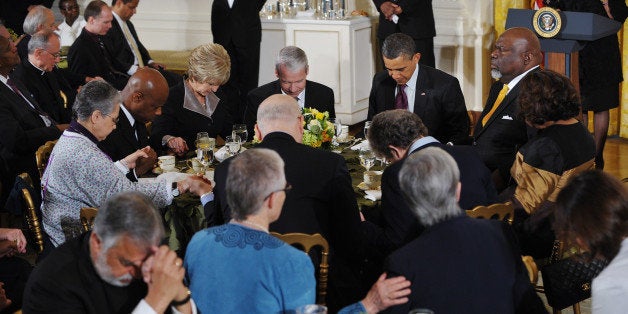 US President Barack Obama bows his head in prayer during an Easter prayer breakfast April 19, 2011 in the East Room of the Wh