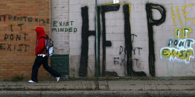 DETROIT - NOVEMBER 20: A pedestrian walks by graffiti on a downtown street November 20, 2008 in Detroit, Michigan. An estimated one in three Detroiters lives in poverty, making the city the poorest large city in America. The Big Three U.S. automakers, General Motors, Ford and Chrysler, are appearing this week in Washington to ask for federal funds to curb to decline of the American auto industry. Detroit, home to the big three, would be hardest hit if the government lets the auto makers fall into bankruptcy. (Photo by Spencer Platt/Getty Images)