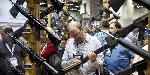 A convention goer examines weapons in the exhibit hall at the143rd NRA Annual Meetings and Exhibits at the Indiana Convention Center in Indianapolis, Indiana, on April 26, 2014. AFP PHOTO / Karen BLEIER (Photo credit should read KAREN BLEIER/AFP/Getty Images)