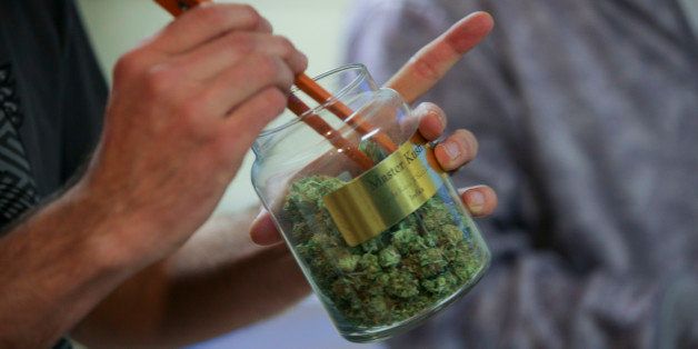 An employee pulls marijuana out of a large canister for a customer at the LoDo Wellness Center in downtown Denver, Colorado, U.S., on Thursday, Jan. 9, 2014. Colorado has just legalized the commercial production, sale, and recreational use of marijuana, while Washington State will begin its own pot liberalization initiative at the end of February. On Jan. 8, New York Governor Andrew Cuomo said his state would join 20 others and the District of Columbia in allowing the drug for medical purposes. Photographer: Matthew Staver/Bloomberg via Getty Images