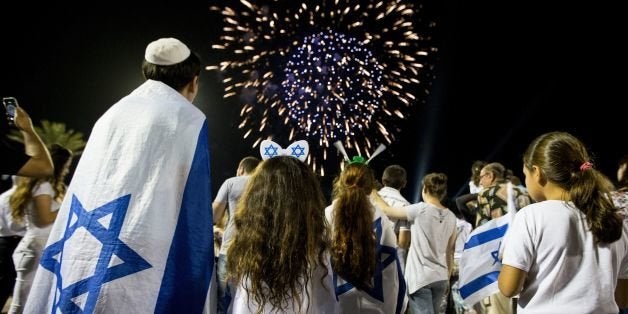 Israeli children watch fireworks in the Mediterranean coastal city of Netanya, on May 5, 2014, during Israel's 66th Independence Day celebrations. Israel's first Prime Minister David Ben-Gurion declared the existence of the State of Israel in Tel Aviv in 1948, ending the British mandate. AFP PHOTO / JACK GUEZ (Photo credit should read JACK GUEZ/AFP/Getty Images)