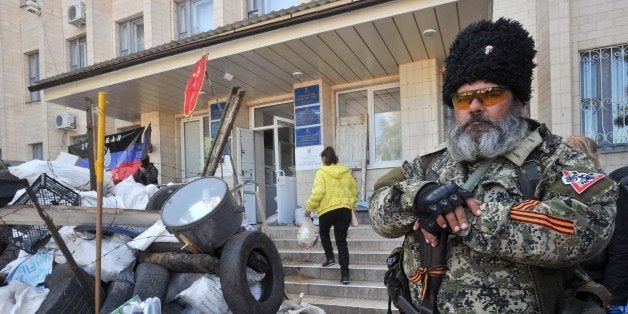 A pro-Russian militants holds a Kalashnikov as he guards a barricade outside the city hall in downtown Kramatorsk, eastern Uk