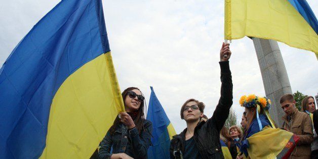 Women wave Ukrainian flags as they take part in a rally for national unity in the eastern Ukrainan city of Donetsk on April 28, 2014. Several people were wounded on April 28 when pro-Russia militants swinging baseball bats and iron bars attacked a rally in the east Ukrainian city of Donetsk marching for national unity, an AFP journalist at the scene witnessed. AFP PHOTO / Alexander KHUDOTEPLY (Photo credit should read Alexander KHUDOTEPLY/AFP/Getty Images)