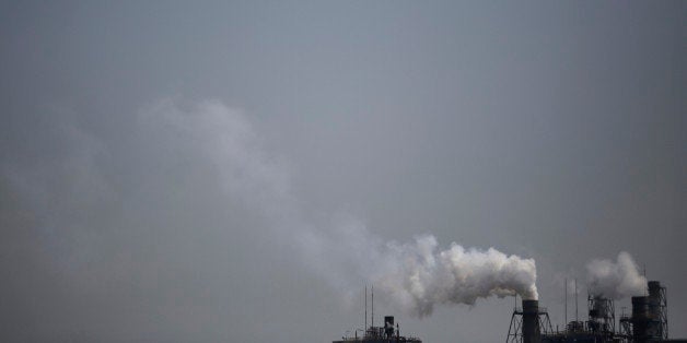 Smoke is discharged from chimneys at a plant in Tokyo, Tuesday, March 25, 2014. Along with the enormous risks global warming
