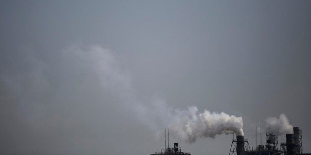 Smoke is discharged from chimneys at a plant in Tokyo, Tuesday, March 25, 2014. Along with the enormous risks global warming poses for humanity are opportunities to improve public health and build a better world, scientists gathered in Yokohama for a climate change conference said Tuesday. (AP Photo/Eugene Hoshiko)