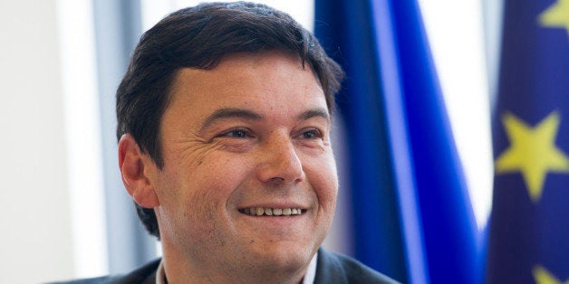 French economist Thomas Piketty smiles during a meeting at the National Assembly on March 13, 2013 in Paris. AFP PHOTO / FRE