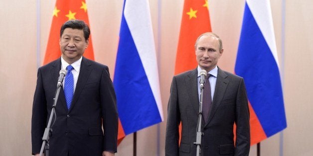 Russia's President Vladimir Putin (R) and his Chinese couterpart Xi Jinping (L) meet in the Russian Black Sea resort of Sochi, on February 6, 2014. Putin will welcome to the Sochi Olympic Games dozens of world leaders supportive of his rule but heads of state of big Western countries will be conspicuous by their absence. AFP PHOTO/ RIA-NOVOSTI/ POOL / ALEXEI NIKOLSKY (Photo credit should read ALEXEI NIKOLSKY/AFP/Getty Images)