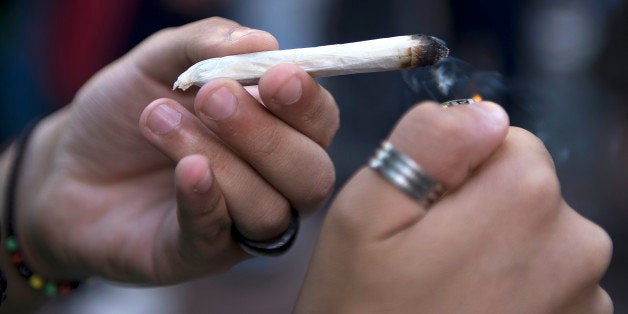 A man lights a joint during a march for the legalization of marijuana towards the Legislative Palace in Montevideo, on Decemb