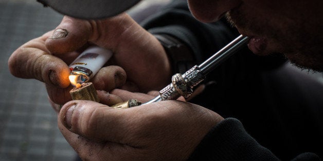 A drug addict lights an improvised pipe in 'Crackolandia', a place where drug addicts gather to smoke crack, in downtown Sao Paulo Brazil on January 11, 2013. AFP PHOTO/Yasuyoshi CHIBA (Photo credit should read YASUYOSHI CHIBA/AFP/Getty Images)