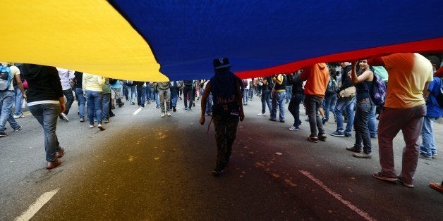 Demonstrators take part in an anti-government rally in Caracas on May 14, 2014. About 80 demonstrators were arrested during a protest as they request the immediate release of youth detained in recent days. AFP PHOTO/JUAN BARRETO (Photo credit should read JUAN BARRETO/AFP/Getty Images)