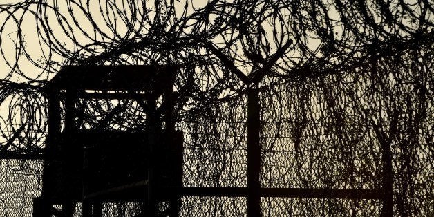 This photo made during an escorted visit and reviewed by the US military, shows the razor wire-topped fence and a watch tower at the abandoned 'Camp X-Ray' detention facility at the US Naval Station in Guantanamo Bay, Cuba, April 9, 2014. AFP PHOTO/MLADEN ANTONOV (Photo credit should read MLADEN ANTONOV/AFP/Getty Images)