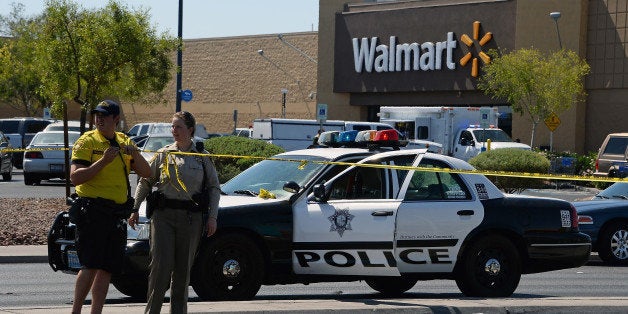 LAS VEGAS, NV - JUNE 08: Las Vegas Metropolitan Police Department officers put police tape up outside a Wal-Mart on June 8, 2014 in Las Vegas, Nevada. Two officers were reported shot and killed by two assailants at a pizza restaurant near the Wal-Mart. The two suspects then reportedly went into the Wal-Mart where they killed a third person before killing themselves. (Photo by Ethan Miller/Getty Images)