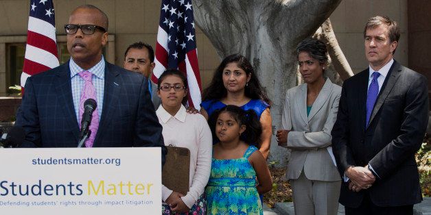 Marcellus McRae, plaintiff's co-lead counsel, with Gibson, Dunn & Crutcher, at podium, is joined with members of Students Matter, a national educational non-profit organization, that helped the plaintiffs on the Vergara v. California lawsuit, as he praises a landmark decision that could influence the gathering debate over tenure across the country in Los Angeles, Tuesday, June 10, 2014. A judge struck down tenure and other job protections for California's public school teachers as unconstitutional Tuesday, saying such laws harm students, especially poor and minority ones, by saddling them with bad teachers. The lawsuit was backed by wealthy Silicon Valley entrepreneur David Welch, seen far right, which assembled a high-profile legal team. (AP Photo/Damian Dovarganes)